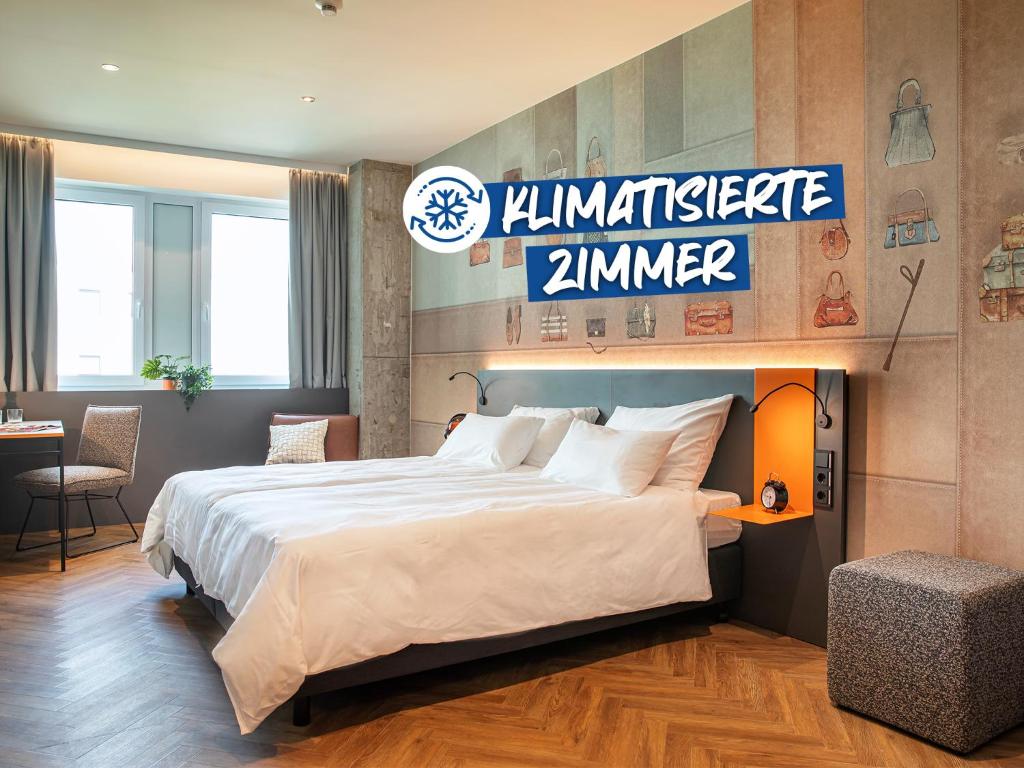 a hotel room with a bed and a sign on the wall at LOGINN Hotel Offenbach in Offenbach