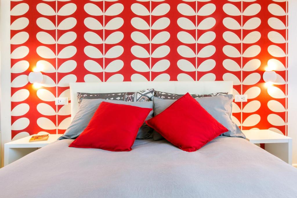 索倫托的住宿－Sorrento Incantata，一张带红色枕头的床和红色及白色的墙壁