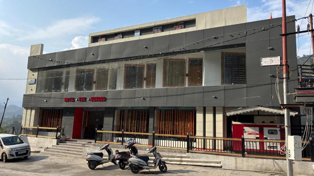 a building with three scooters parked in front of it at Hotel The SunGod in Uttarkāshi