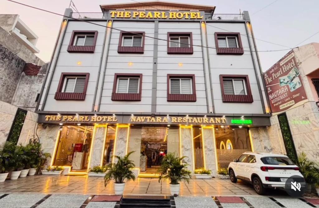 a building with a car parked in front of it at The Pearl Hotel Rampur in Rāmpur