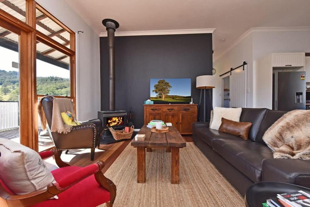 a living room with a couch and a fireplace at The Glass Ceiling 360 degree Mount View Hideaway in Mount View