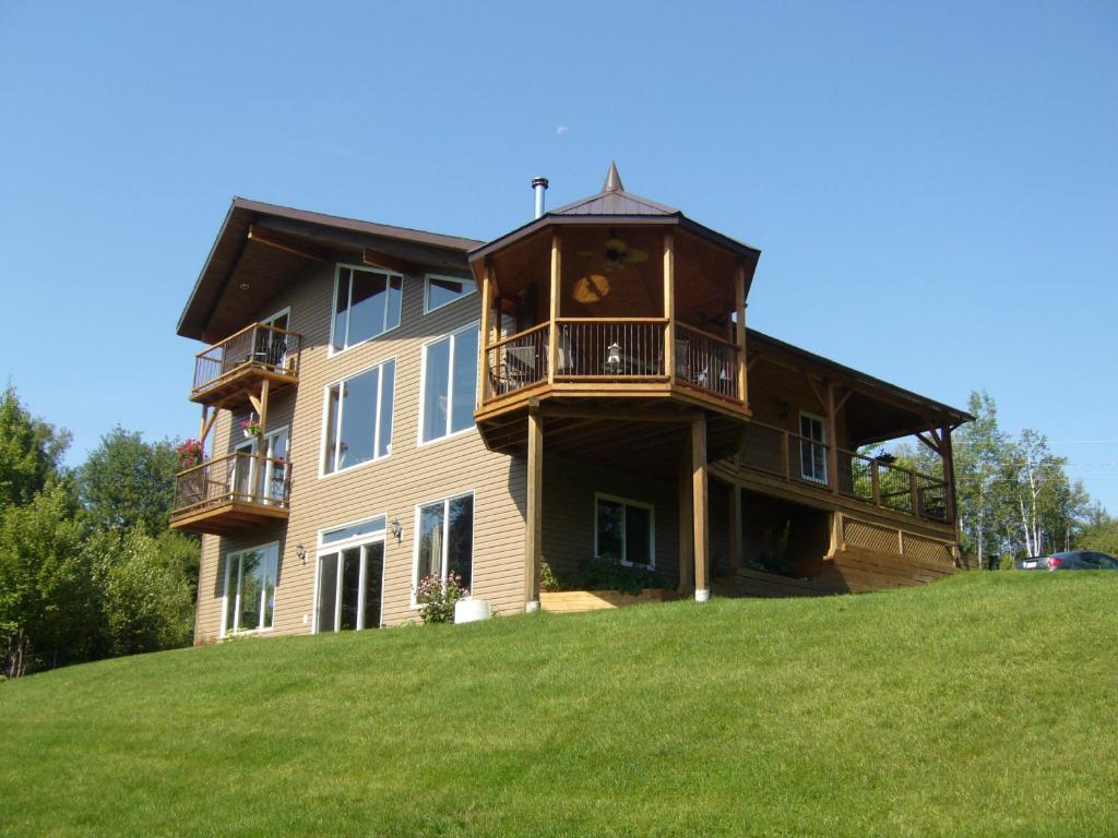 una casa grande en la cima de una colina con césped en Strong Timbers BnB, en Kingsclear