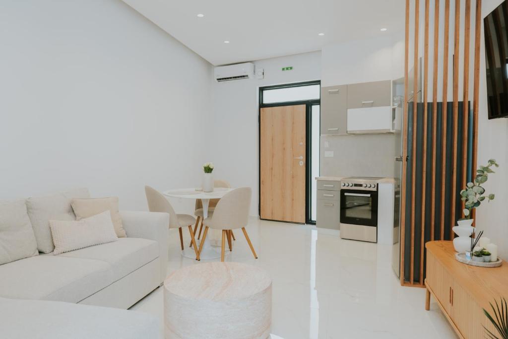 a white living room with a white couch and a table at Chez Jean in Argos