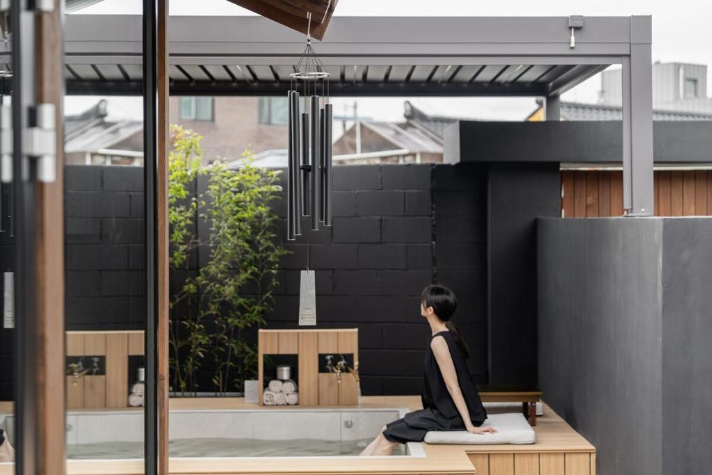 a person sitting in a yoga position on a bench at 한옥스테이 서유재 in Ch'unch'ŏn-yŏk