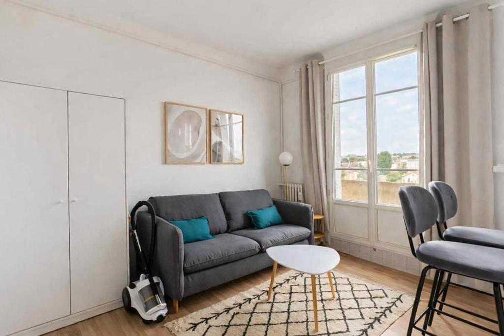 a living room with a couch and a chair at Bright Studio Near Paris & Disneyland in Neuilly-Plaisance