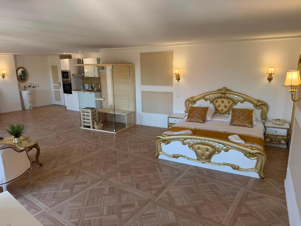 a bedroom with a king sized bed and a kitchen at Suite Lisa in La Roche-Blanche