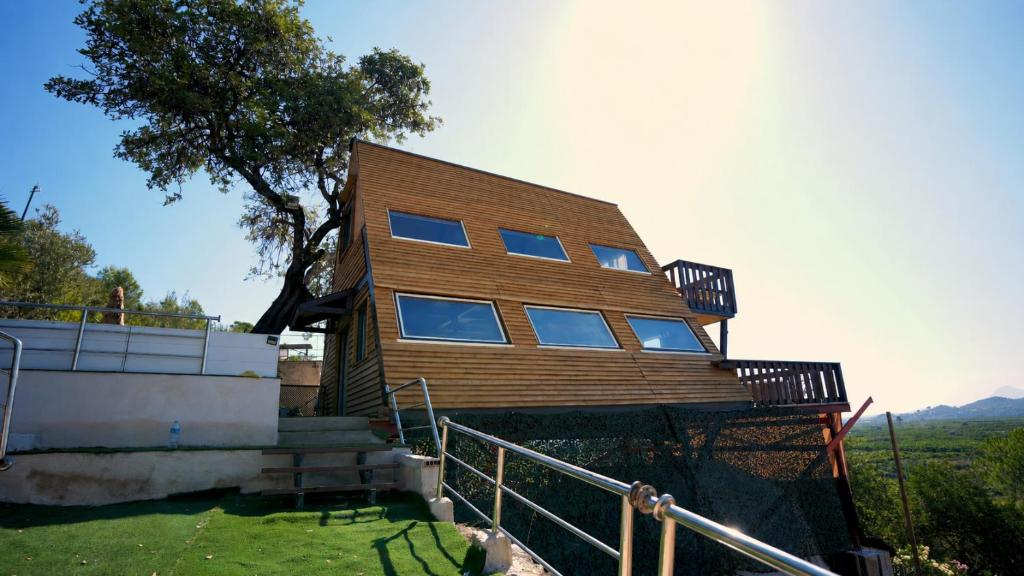 a wooden house withwindows on the side of it at Cabin with jacuzzi and spectacular views in Oliva