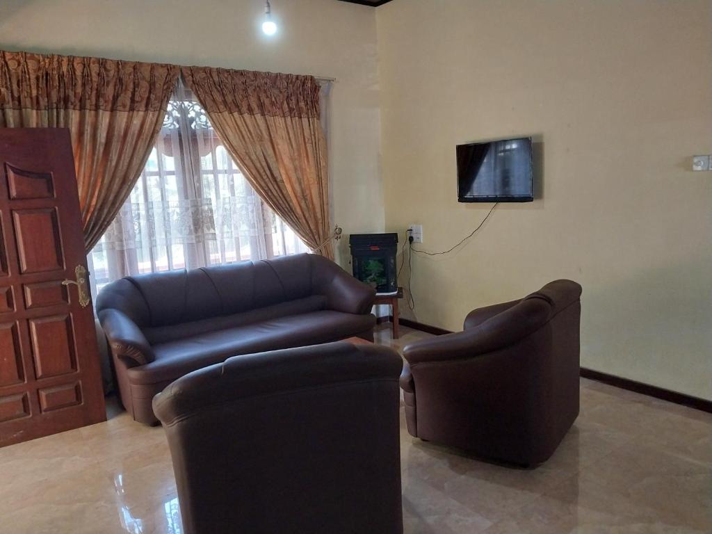 a living room with a couch and a tv at Miriswaththa resort in Deniyaya