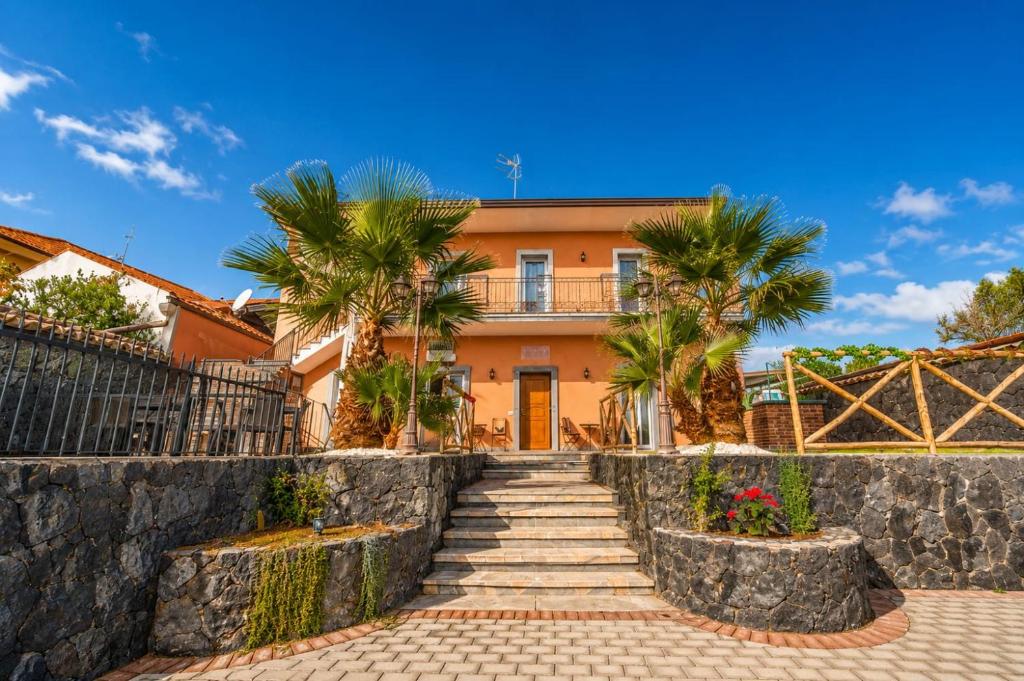 a house with palm trees in front of it at Martina paradise Etna in Nicolosi