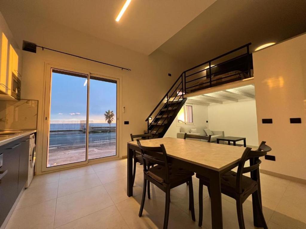 a dining room with a table and a loft bed at Vista Mare in Cipressa
