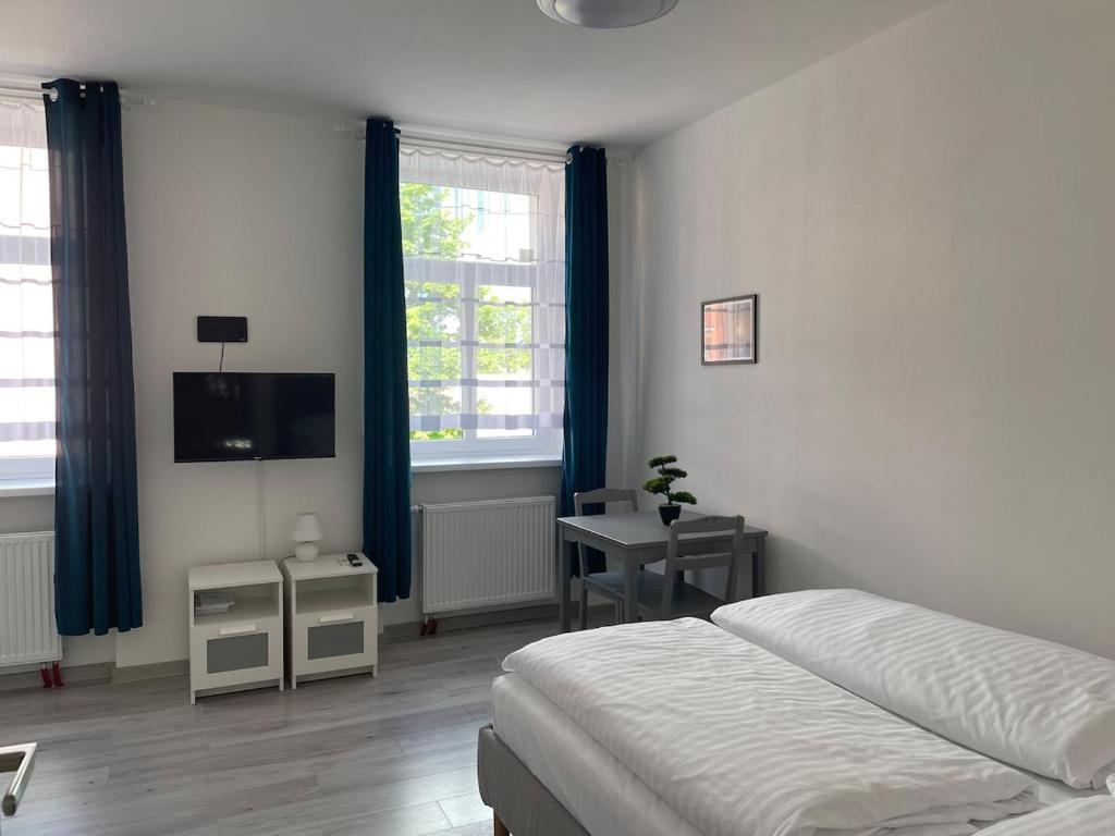 a bedroom with a bed and a tv and a desk at Apartman cheb in Cheb