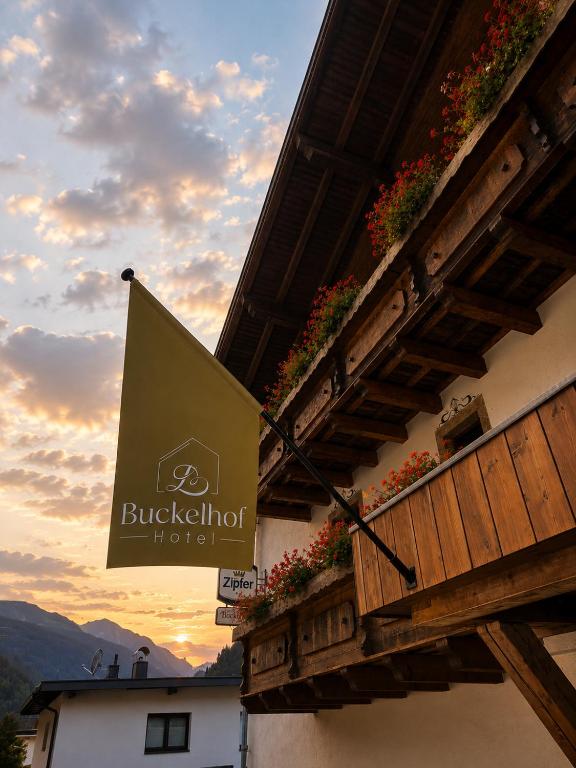 a sign on the side of a building with flowers at Hotel Buckelhof - See - Free Liftpass Summer in See