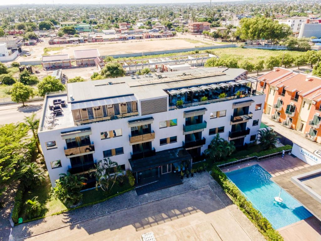 an aerial view of a white building with a swimming pool at Hotel Lunamar in Beira