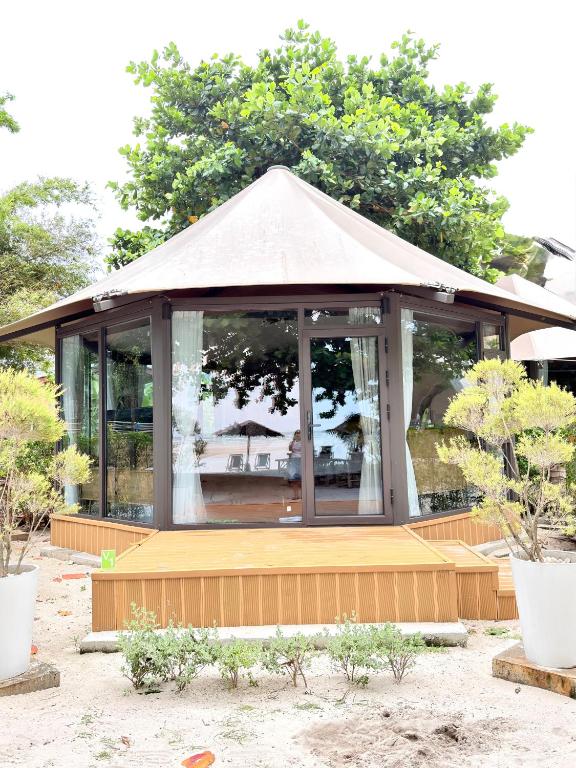 a gazebo with a porch with trees in the background at Umbrella tree v1 in Nathon