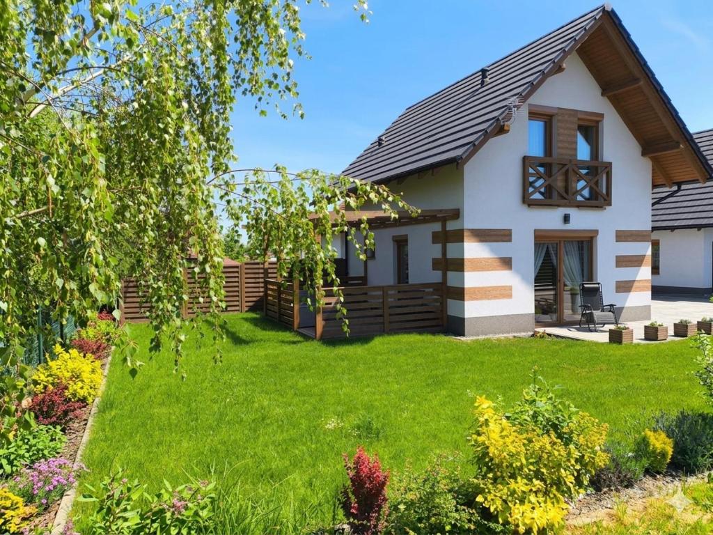 a house with a green lawn in front of it at Domy w Górach Łomnica in Łomnica