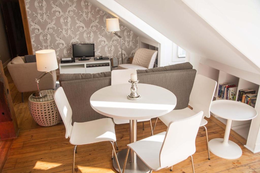 sala de estar con mesa blanca y sillas en FLH Chiado Terrace Flat, en Lisboa