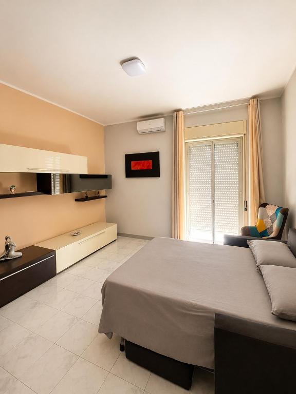 a bedroom with a large bed and a couch at Appartamento Mina' in Adrano