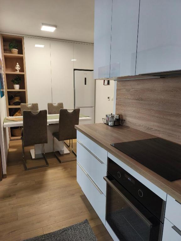 a kitchen with white cabinets and a table with chairs at Apartment with parking in the city center in Staré Mesto