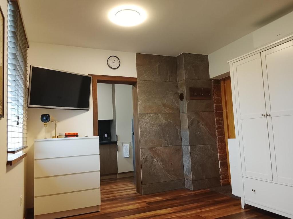 a bathroom with a shower and a tv on the wall at Minija Stay Priekule 1925 in Priekulė