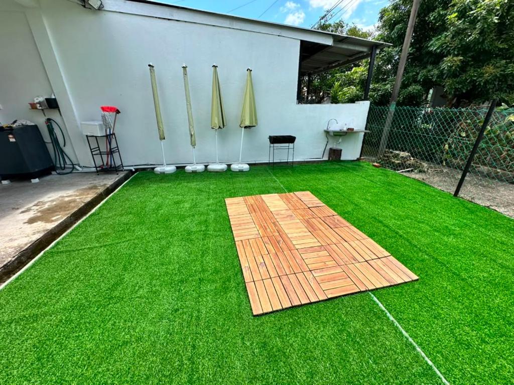 a backyard with a green lawn with a wooden deck at Permaisuri homestay in Bintulu