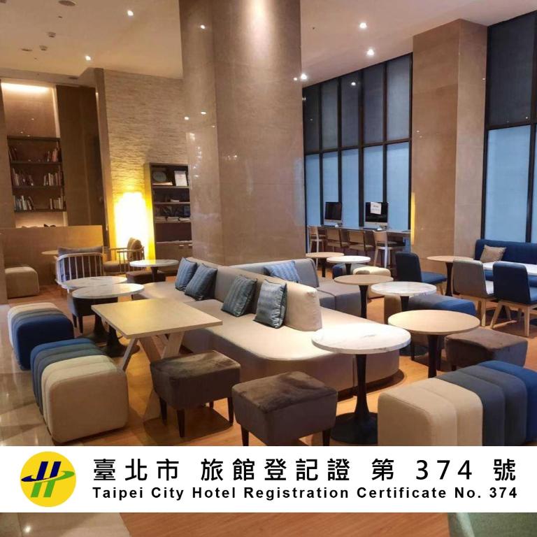a hotel lobby with tables and chairs at City Suites - Taipei Nandong in Taipei