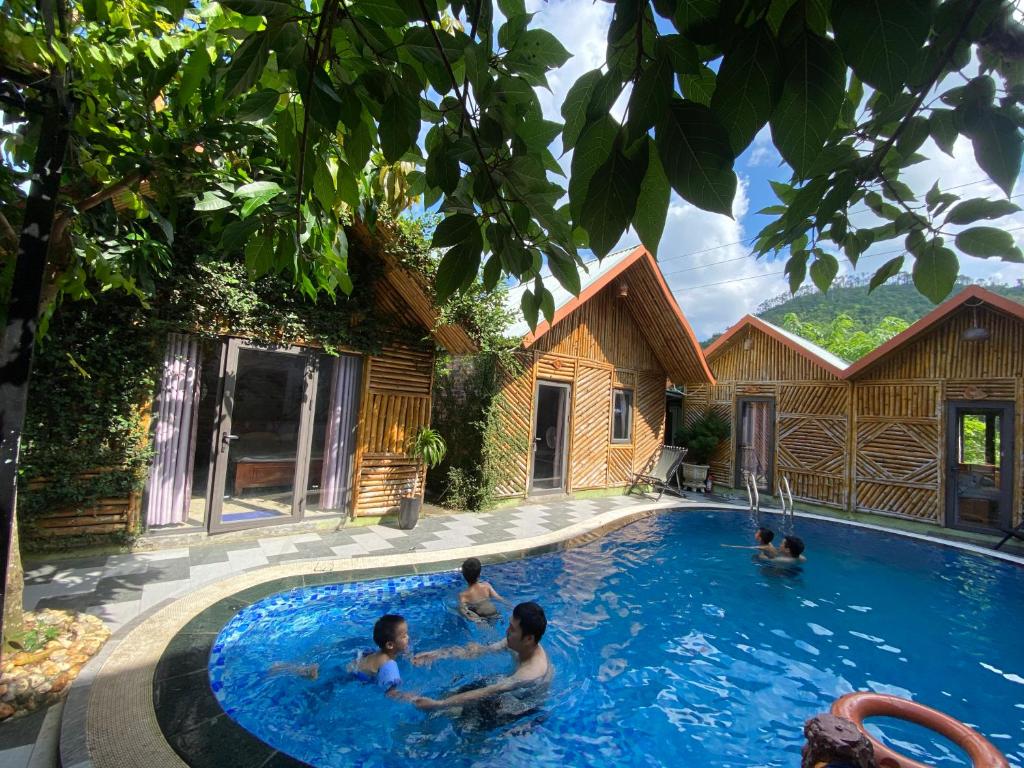a group of people swimming in a swimming pool at Cat Ba Rustic Homestay in Cat Ba