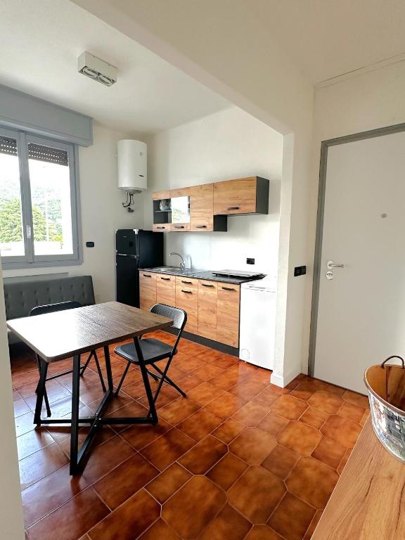 a room with a table and a kitchen with a counter at Smart Living Tavernerio in Tavernerio