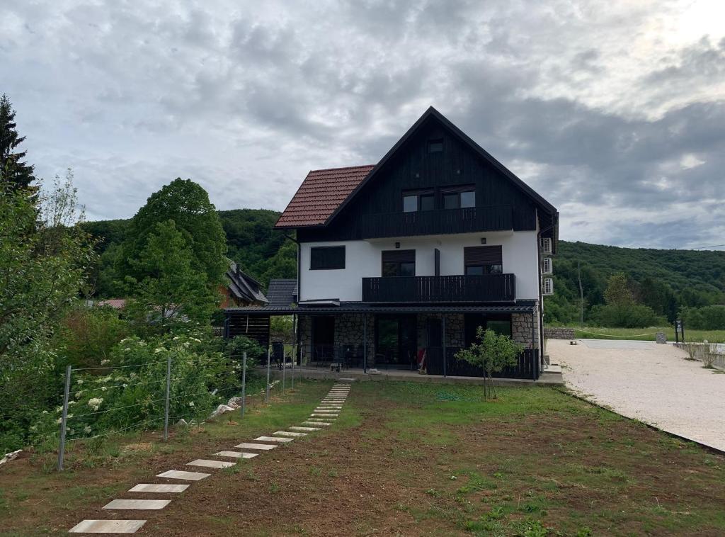 a large black and white house with at Guesthouse Family Bosnic in Plitvička Jezera
