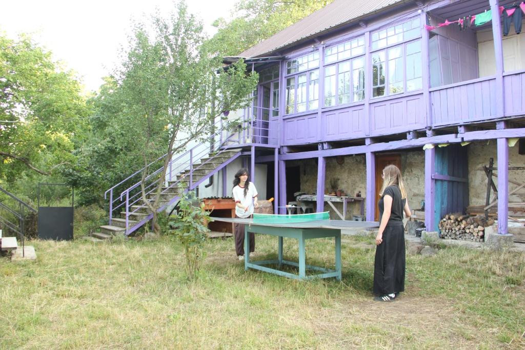 two women standing in front of a purple building at Lilac Orbeti - Cool Climate Country House Near Tbilisi in Pantiani