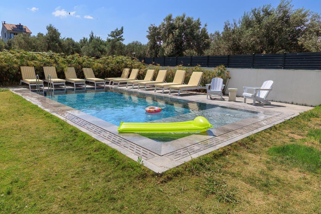 a pool with chairs and a inflatable pool slide at Cedori Butik Otel in Ezine