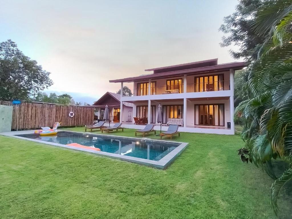 a house with a swimming pool in the yard at Ploythai Villa 2 in Haad Pleayleam