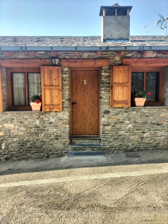 a stone building with wooden doors and windows at Cal Rafalet in Ger