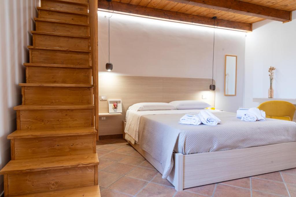 ein Schlafzimmer mit einem Bett mit weißen Laken und einer Treppe in der Unterkunft Da Concy in Castelmezzano