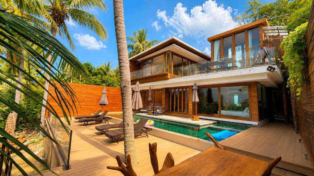 a villa with a swimming pool and a house at Villa Amrita - Oceanfront Villa with Private Beach in Ko Phangan