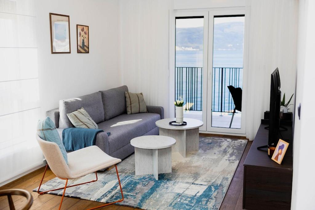 a living room with a couch and a tv at Azure Sunset in Donja Lastva