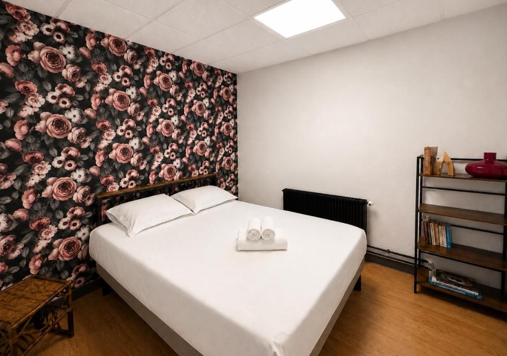 a bedroom with a bed with a floral wallpaper at Grand T4 Compiègne in Compiègne