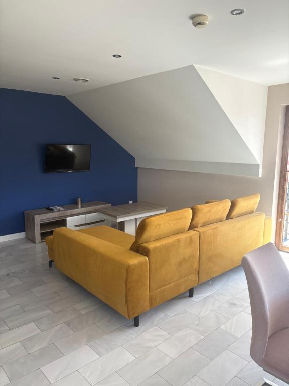 a living room with a couch and a tv at W Dolinie in Małkowice