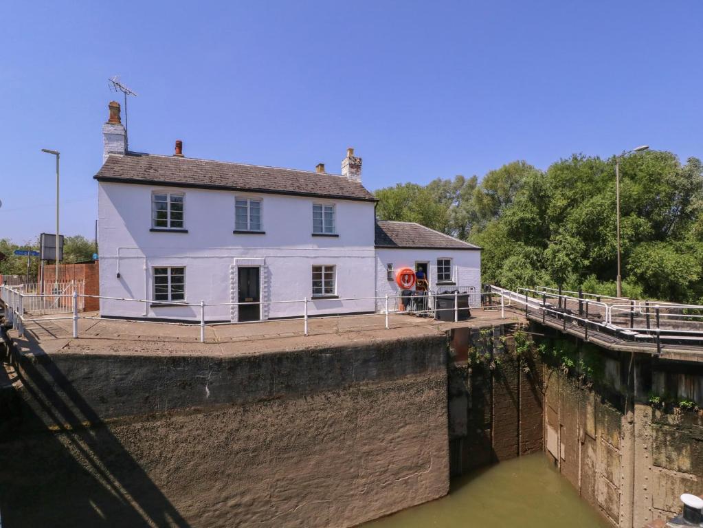 a white house on the side of a canal at The Lock House in Gloucester
