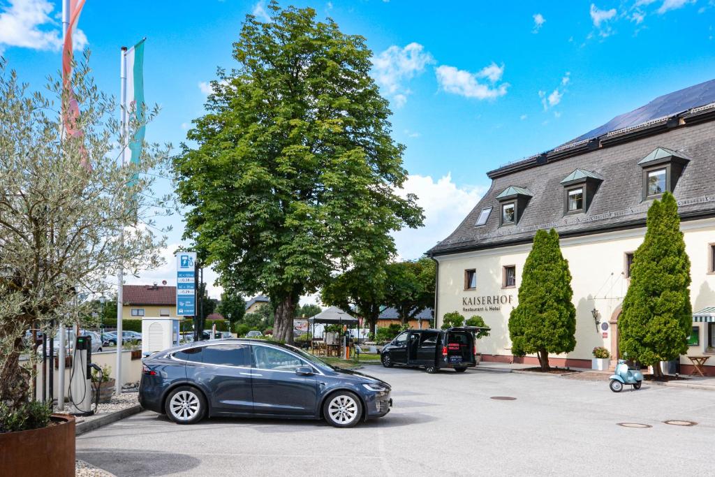 a car parked in a parking lot in front of a building at Hotel Kaiserhof in Anif