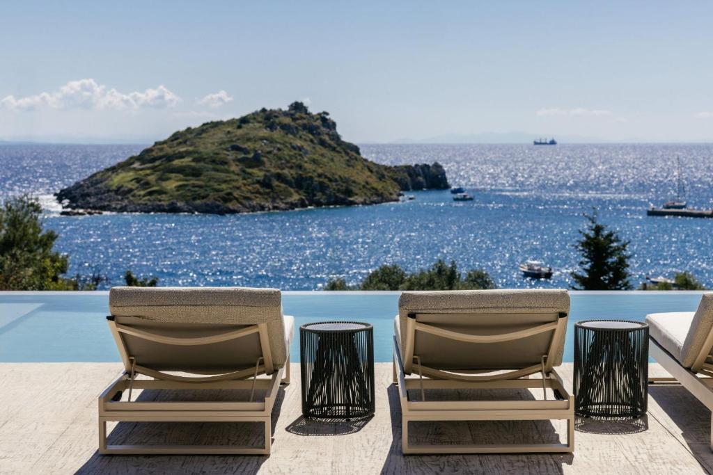 two chairs sitting on a patio overlooking the ocean at Apaggio Luxury Villa - Private Pool & Stunning Sea Views, by ZanteWize in Agios Nikolaos