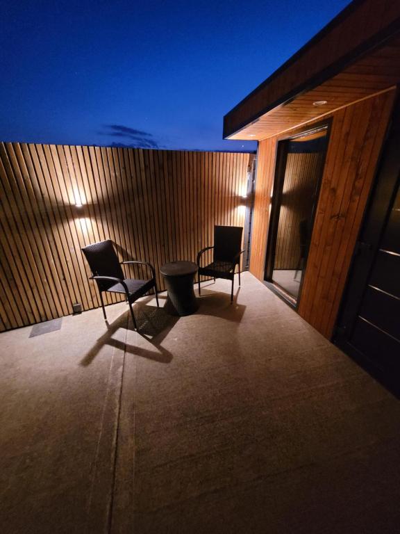 two chairs and a table on a balcony at night at Rose Cottage Clonmel in Clonmel