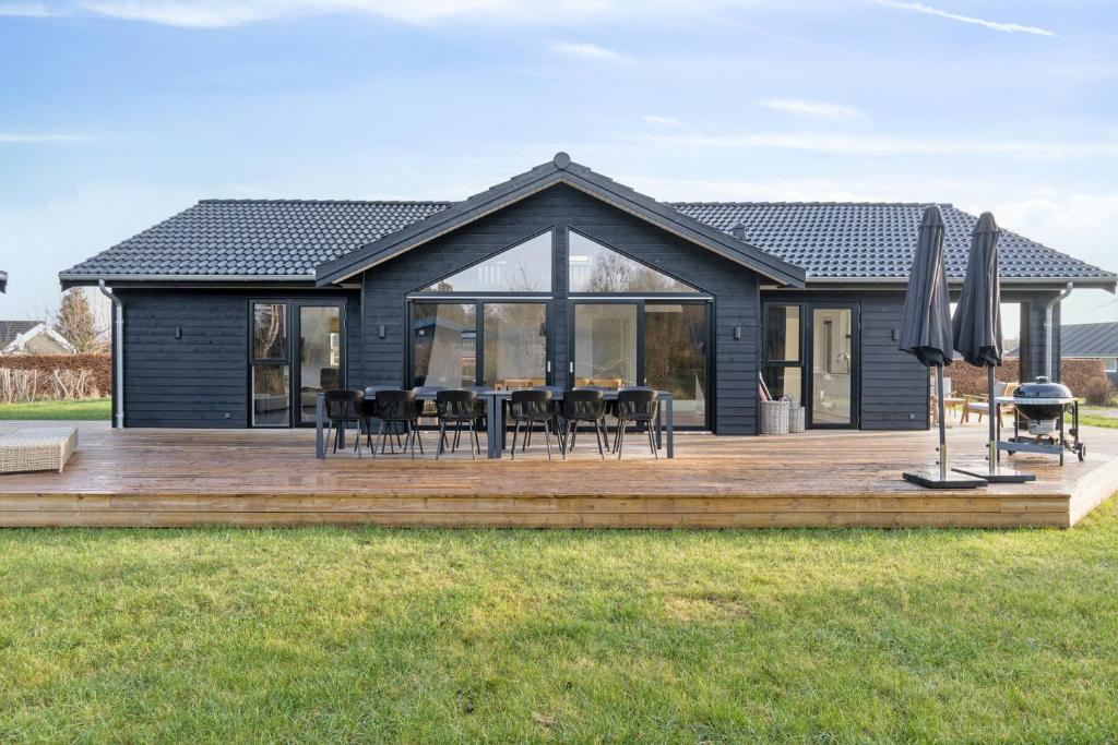 a house with a wooden deck in the grass at Modern Holiday Home With Annex And 10 Beds in Rude