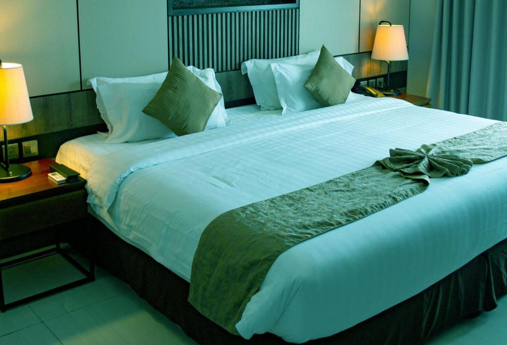 a large bed in a hotel room with a bow on it at Tharusha Hotel in Udawalawe
