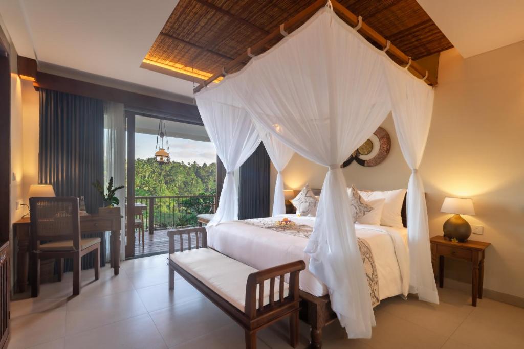 a bedroom with a canopy bed and a balcony at The Compass Rose Valley in Ubud
