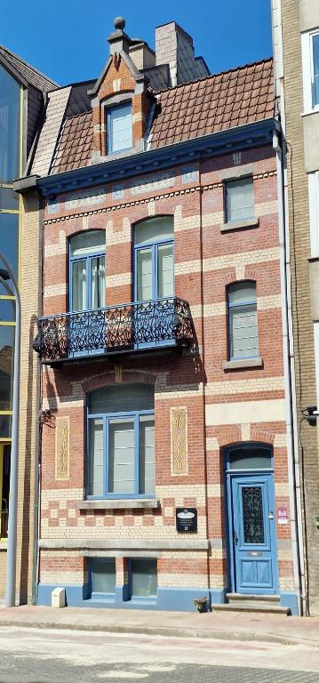 a brick building with a balcony on the side of it at B&B Villa Des Raisins in Bruges