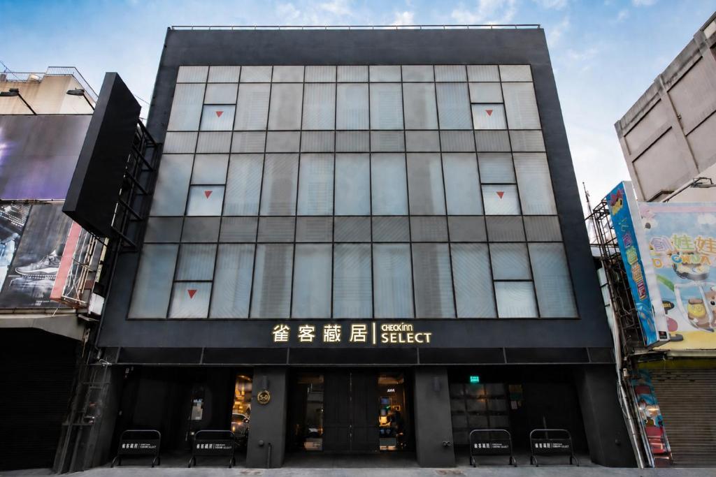 ein hohes schwarzes Gebäude mit Fenstern auf einer Straße in der Unterkunft CHECK inn SELECT Chiayi RenAi in Chiayi