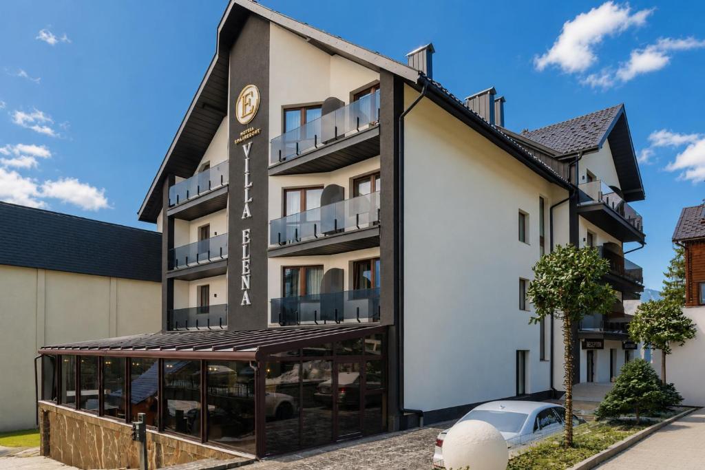 a building with a car parked in front of it at Villa Elena SPA & Resort in Bukovel