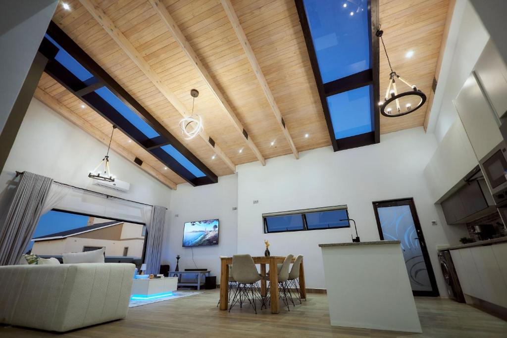 a living room with large windows and a table at Pomona Palm Villa in Harare