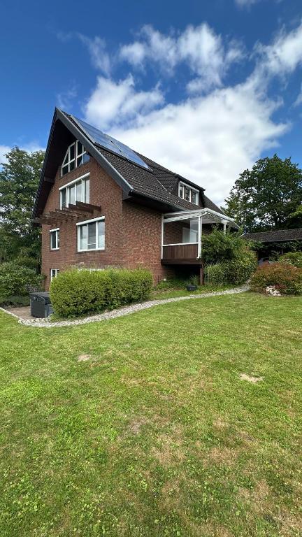 a brick house with a large lawn in front of it at Haus Sonnenwest in Rosengarten