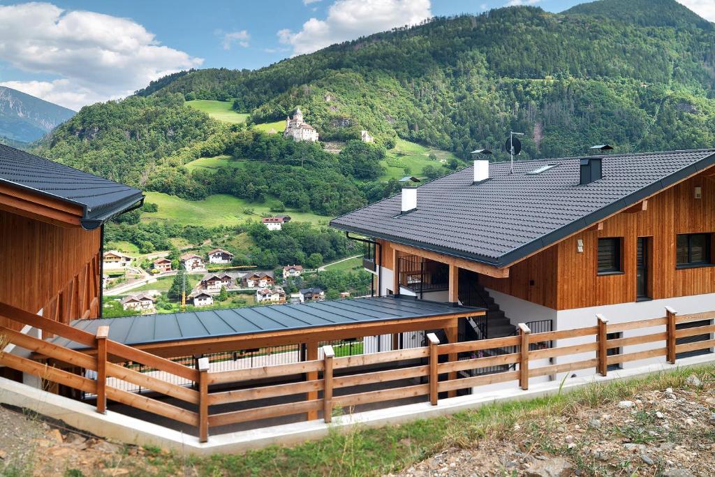 a house with a wooden fence in front of a mountain at Oberstarzerhof in Barbiano